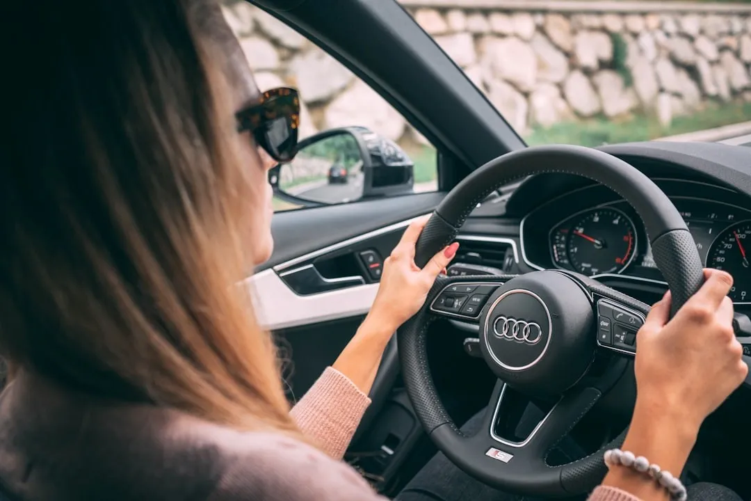Jonge vrouw rijdt zelfverzekerd achter het stuur van een auto, symbool voor vrijheid en mobiliteit tijdens je studie