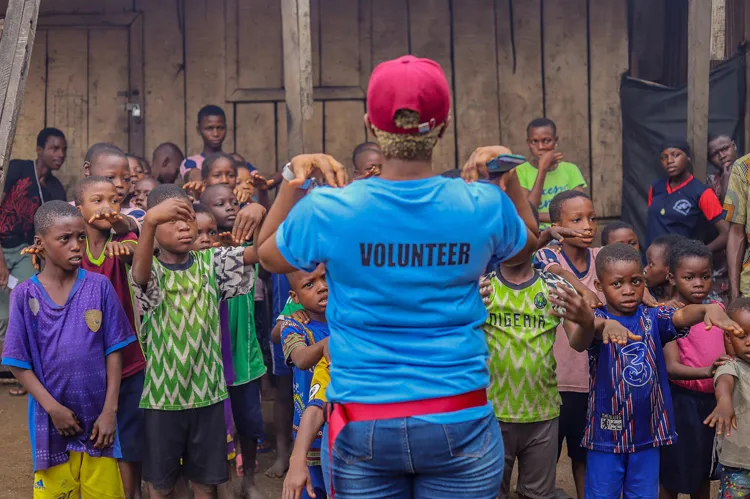 Vrijwilliger geeft les aan kinderen in een Afrikaans community-project