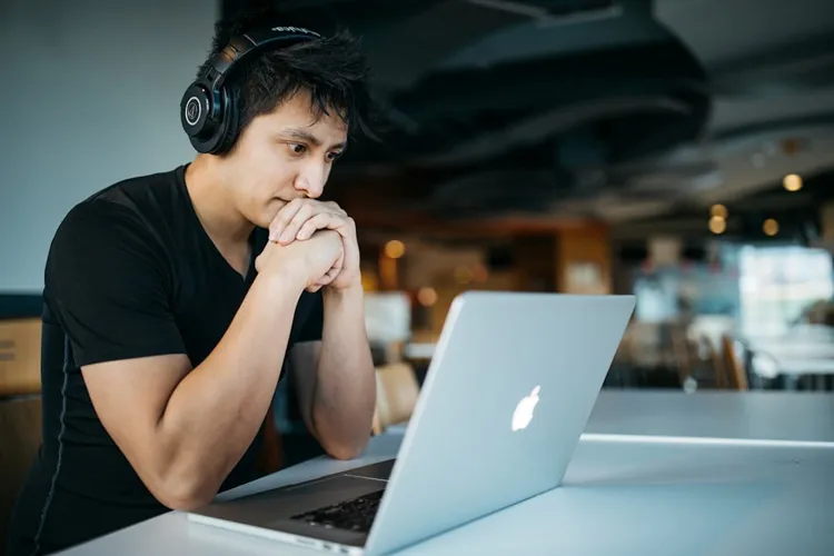 Student bouwt geconcentreerd aan zijn eigen website op een laptop